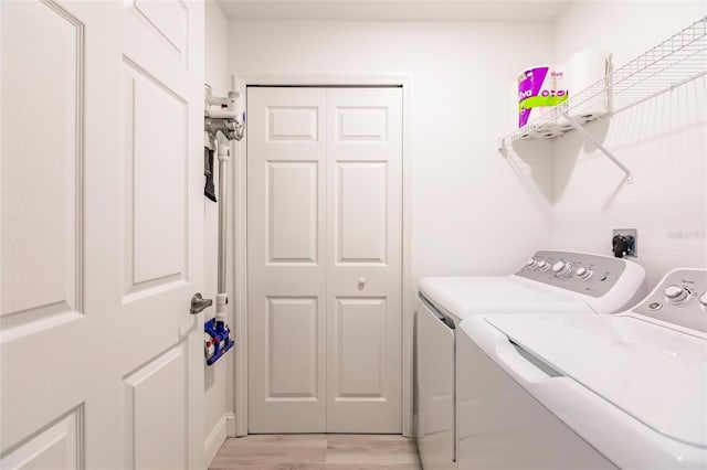 washroom featuring washer and clothes dryer and light hardwood / wood-style floors