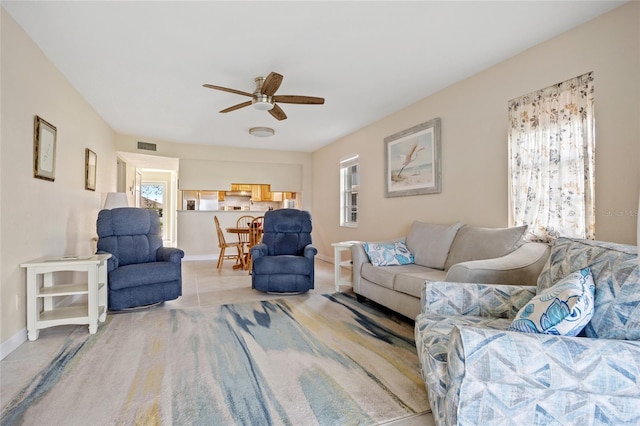 living room featuring ceiling fan and a healthy amount of sunlight