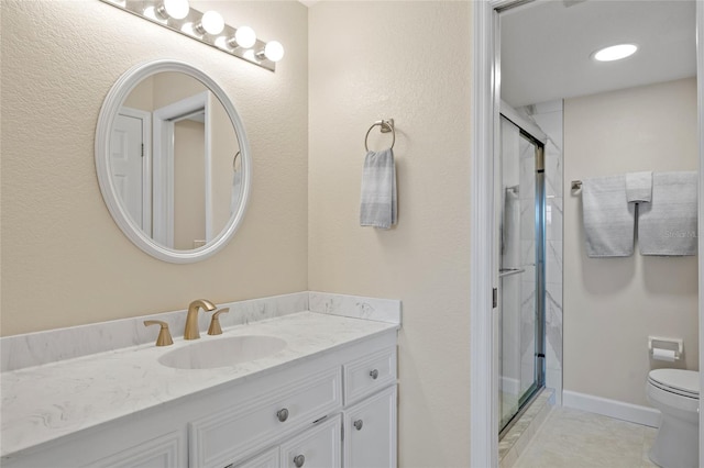 bathroom featuring tile patterned flooring, vanity, a shower with shower door, and toilet