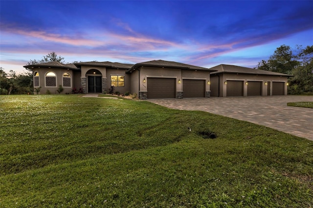 prairie-style home featuring a lawn and a garage