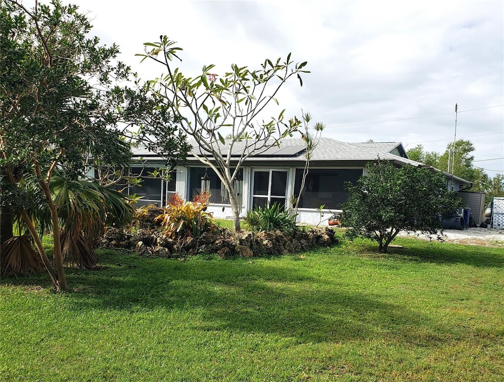 exterior space featuring a lawn and solar panels