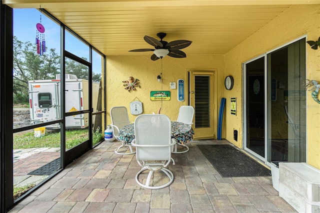 sunroom / solarium featuring ceiling fan