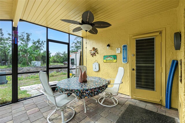 sunroom / solarium featuring ceiling fan and lofted ceiling with beams