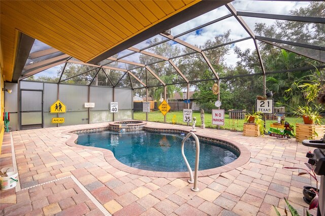 view of pool featuring glass enclosure and a patio