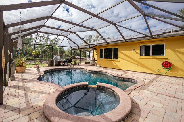 view of pool with a lanai, an in ground hot tub, and a patio