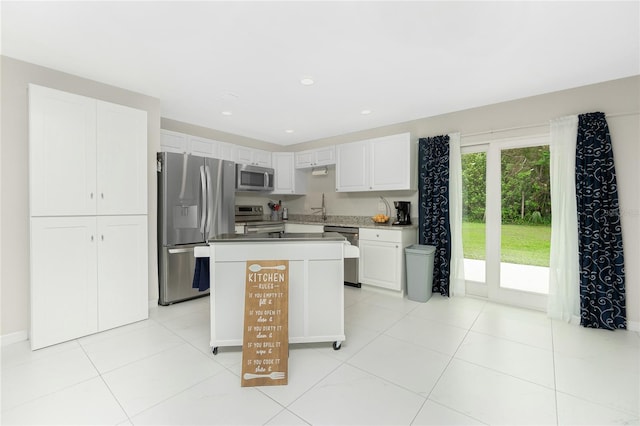 kitchen featuring white cabinetry, sink, a kitchen island, and appliances with stainless steel finishes