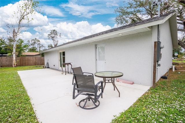 rear view of house with a patio and a lawn