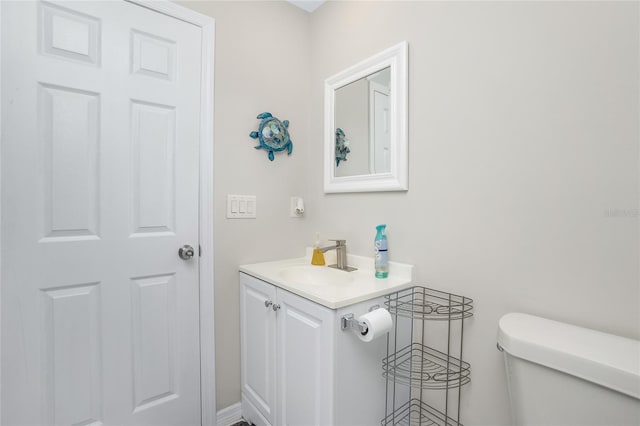 half bathroom with vanity and toilet