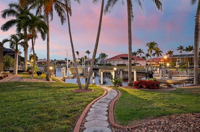 exterior space with a water view, a yard, and a dock