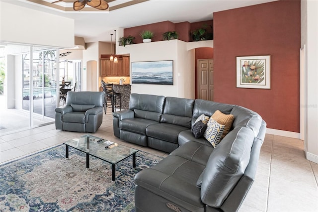 living room with light tile patterned floors, ornamental molding, and ceiling fan