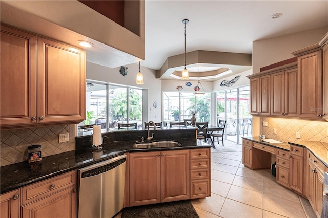 kitchen featuring pendant lighting, dishwasher, sink, and dark stone countertops