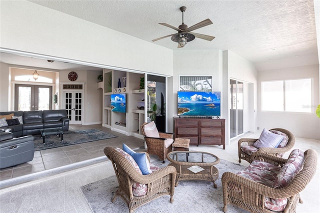 living room with ceiling fan, a textured ceiling, and french doors