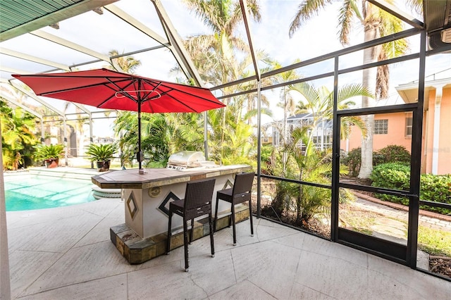 exterior space featuring an outdoor kitchen, a patio area, a lanai, a grill, and exterior bar