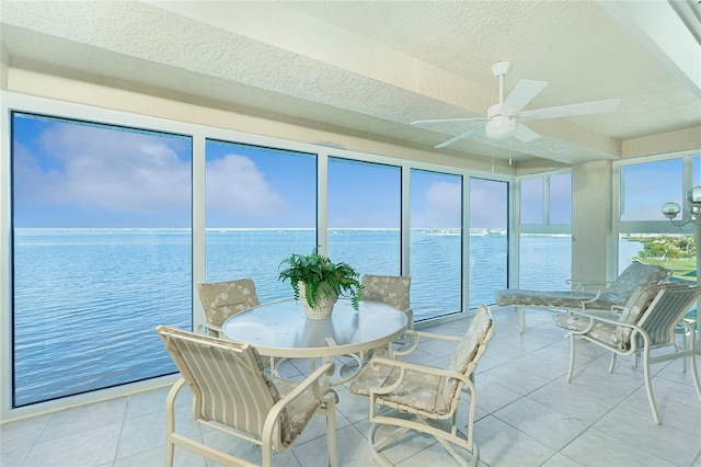 sunroom / solarium with a water view and ceiling fan