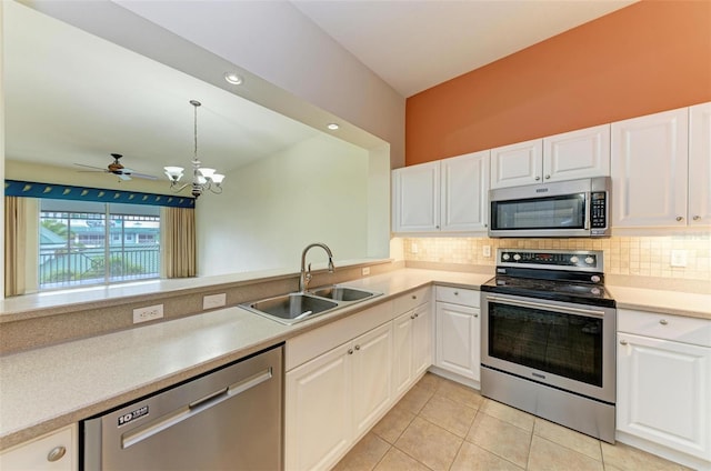 kitchen with pendant lighting, white cabinets, ceiling fan with notable chandelier, sink, and stainless steel appliances