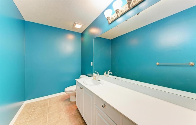 bathroom with tile patterned floors, vanity, a textured ceiling, and toilet