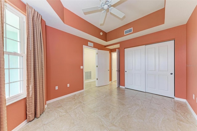 unfurnished bedroom featuring multiple windows, a closet, and ceiling fan