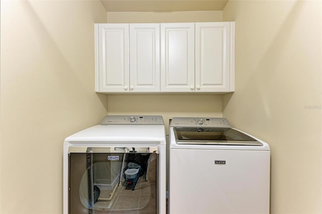 washroom featuring cabinets and washing machine and dryer