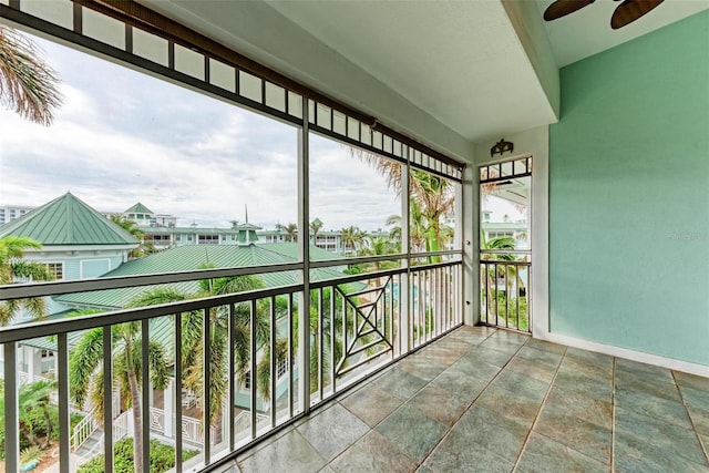 unfurnished sunroom with ceiling fan