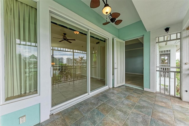 unfurnished sunroom with ceiling fan