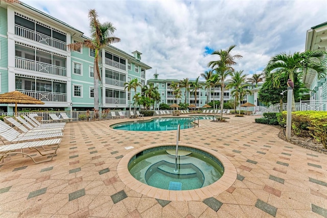 view of swimming pool featuring a patio and a hot tub