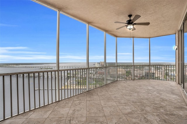 unfurnished sunroom featuring ceiling fan