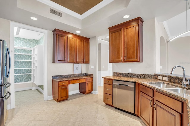 kitchen with sink, dark stone countertops, crown molding, a tray ceiling, and appliances with stainless steel finishes