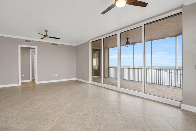 empty room featuring floor to ceiling windows, a water view, crown molding, and light tile patterned flooring