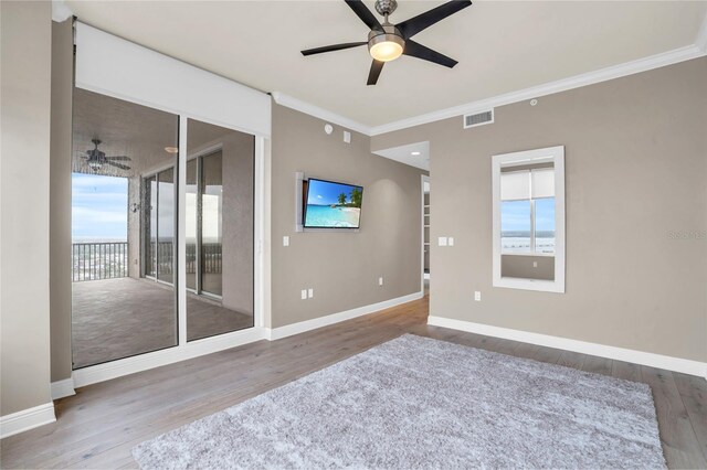 unfurnished room with hardwood / wood-style floors, plenty of natural light, ceiling fan, and ornamental molding