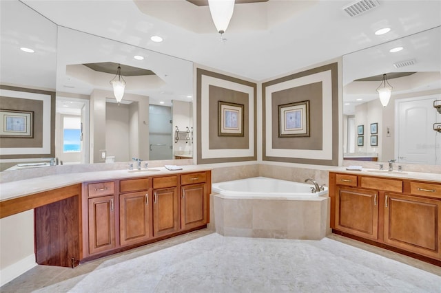 bathroom featuring vanity and tiled bath