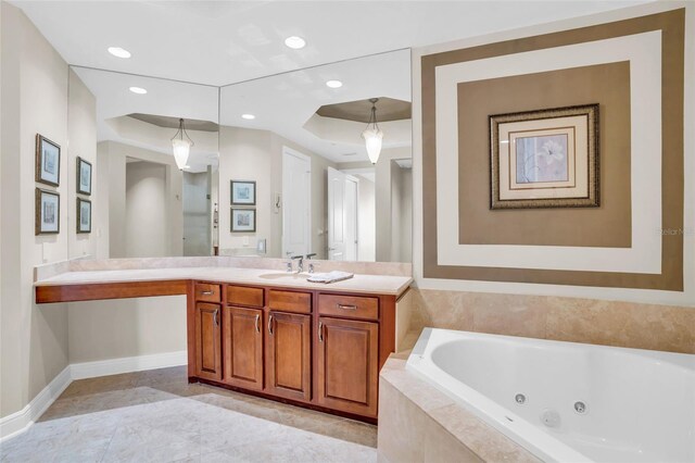 bathroom with tile patterned floors, tiled tub, and vanity