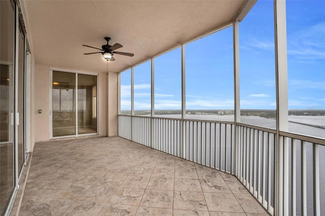 unfurnished sunroom featuring ceiling fan