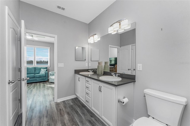 bathroom with vanity, toilet, and hardwood / wood-style floors