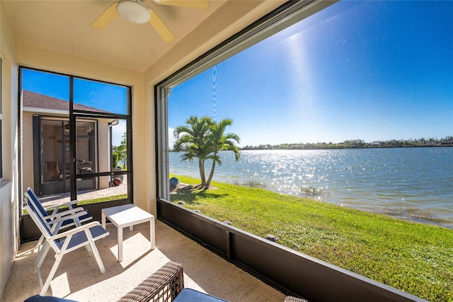 sunroom / solarium with ceiling fan and a water view