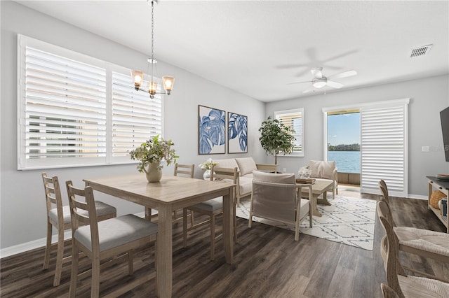 dining space featuring dark hardwood / wood-style floors and ceiling fan with notable chandelier