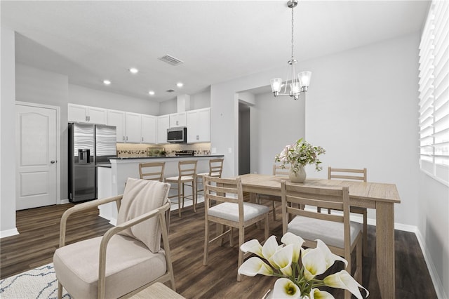 dining area featuring an inviting chandelier and dark hardwood / wood-style floors