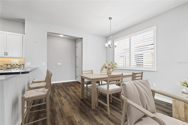 dining space featuring an inviting chandelier, dark wood-type flooring, and a textured ceiling