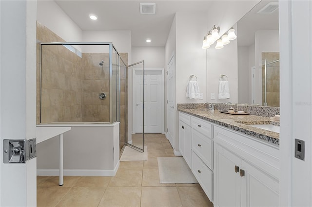 bathroom featuring tile patterned flooring, vanity, and a shower with door