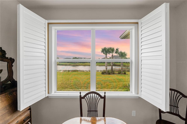 dining space featuring a water view and a healthy amount of sunlight