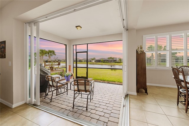 sunroom / solarium featuring a water view