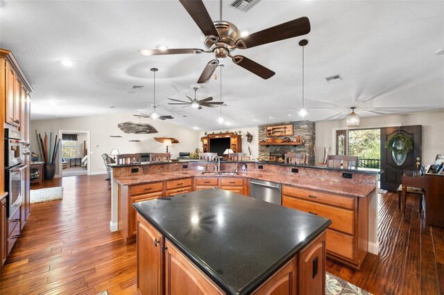 8625 SW County Road 769, Arcadia, FL 34269 - kitchen with a large island with sink, dishwasher, a fireplace, a ceiling fan, and open floor plan