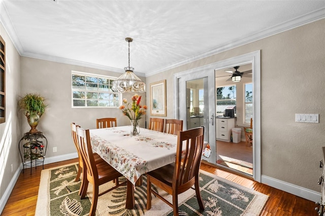 dining room with hardwood / wood-style floors, crown molding, and a notable chandelier