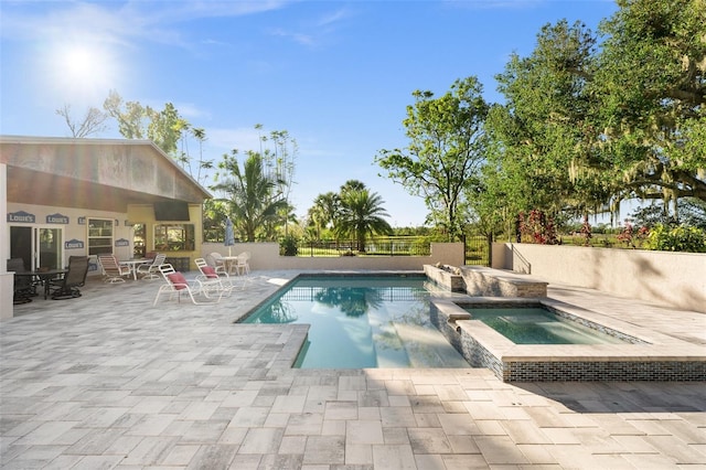 view of swimming pool featuring a patio area and an in ground hot tub