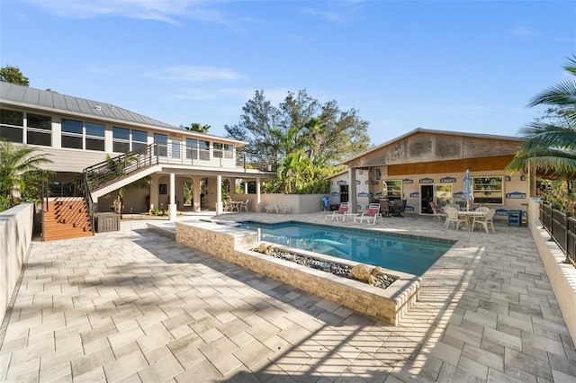 view of swimming pool with a jacuzzi, a patio area, and an outdoor fire pit