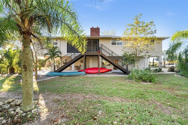 rear view of house with a sunroom and a lawn