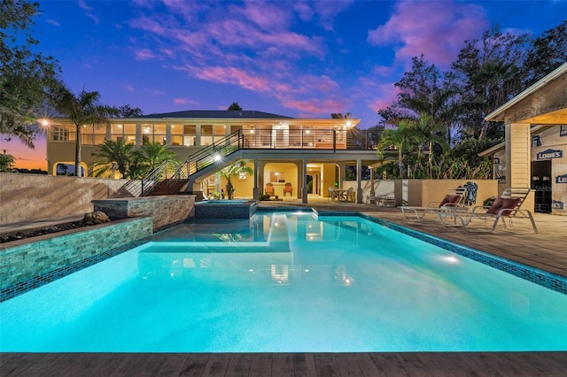 8625 SW County Road 769, Arcadia, FL 34269 - pool at dusk with stairs, a pool with connected hot tub, a patio, and a deck