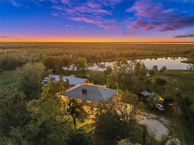 aerial view at dusk featuring a water view