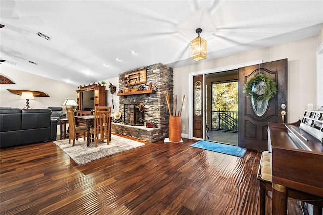 entryway featuring vaulted ceiling, dark hardwood / wood-style floors, and a fireplace