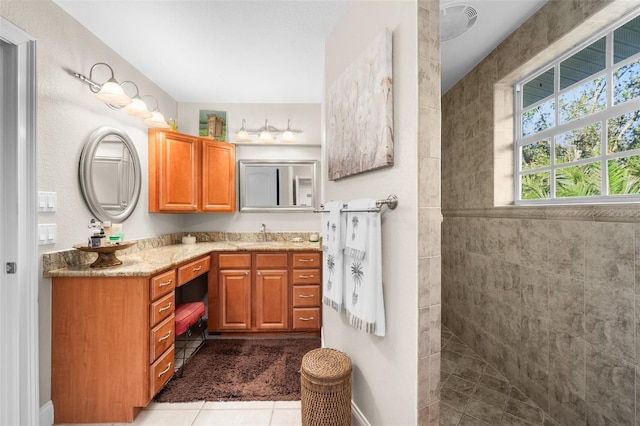 bathroom featuring vanity, tile patterned floors, and tiled shower