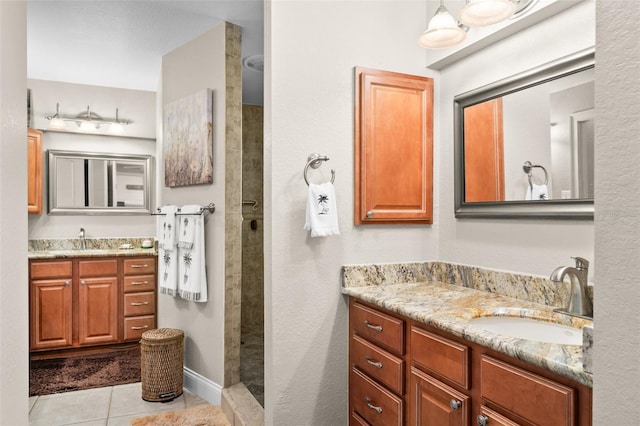 bathroom with vanity, tile patterned floors, and tiled shower